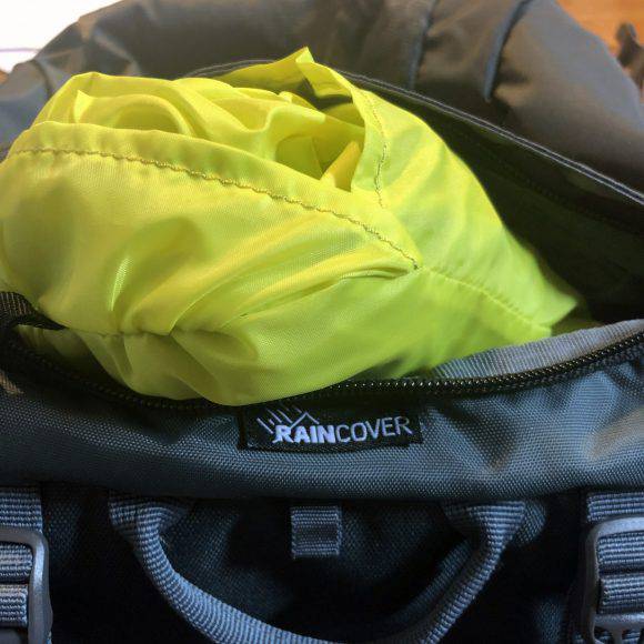 Il telo anti pioggia dello zaino Millet Ubic 40 è contenuto nella tasca superiore del cappuccio e affrancato con una cinghia con gancio