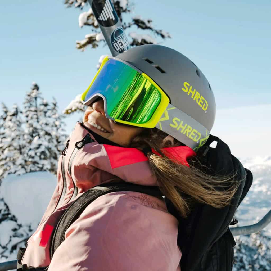 Casco da sci con visiera colorata, donna che si gode la neve in montagna in inverno.