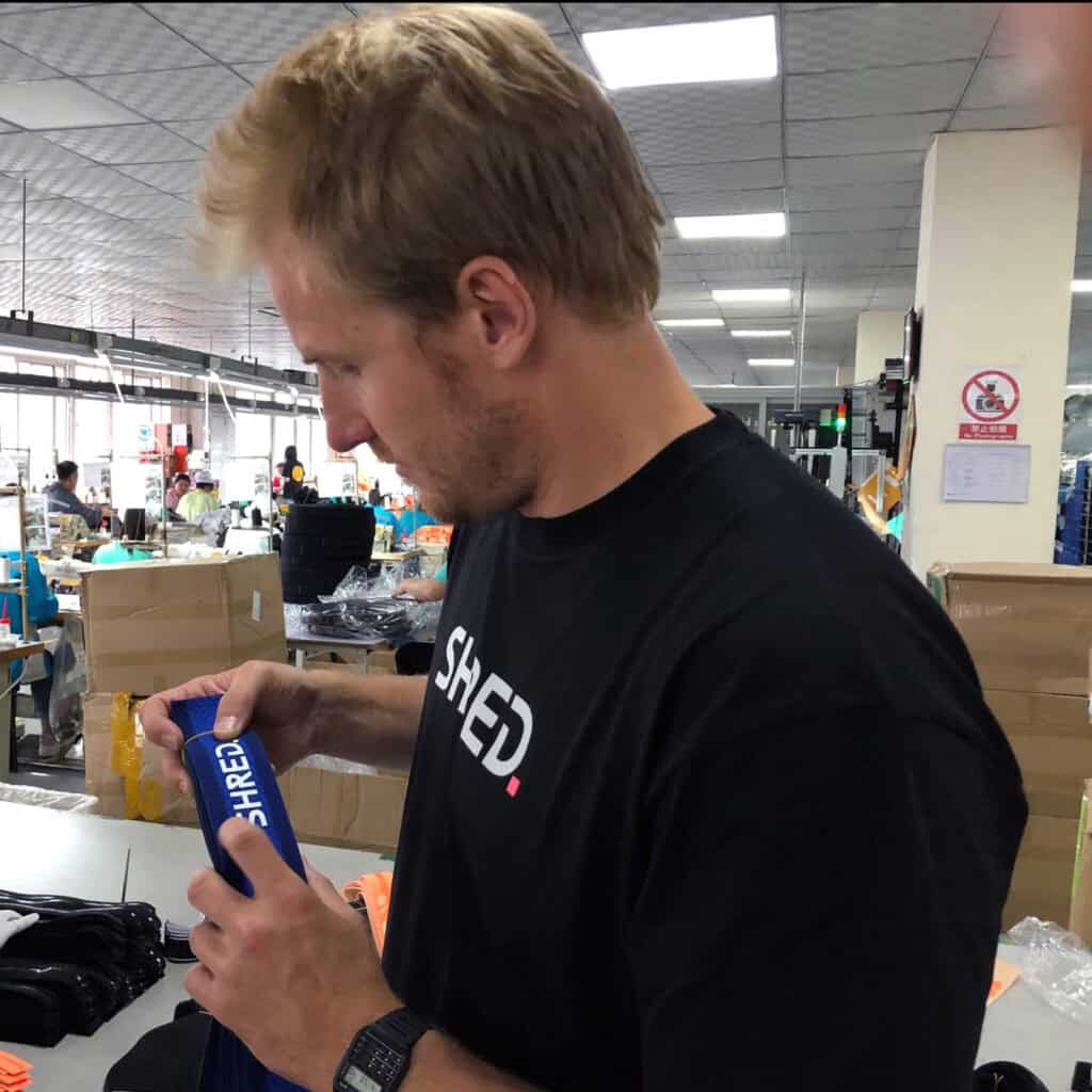 Produttore al lavoro in fabbrica di attrezzature outdoor, confezionamento prodotti per attività outdoor e sport.