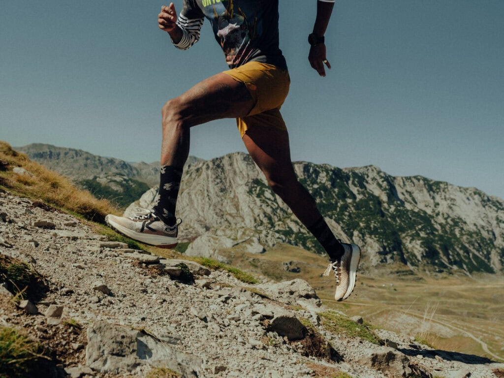 Trail runner climbing rocky mountain trail KEEN outdoor running shoes